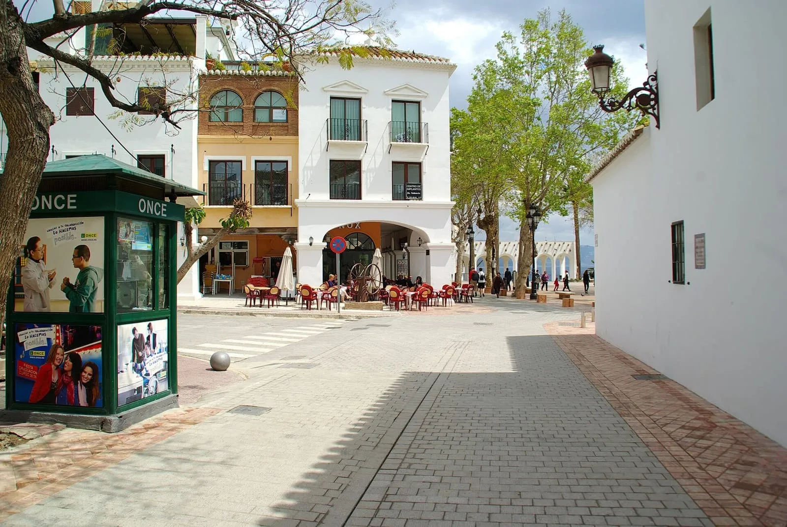 Terrazas de bares con mesas y sombrillas en una calle peatonal de Nerja